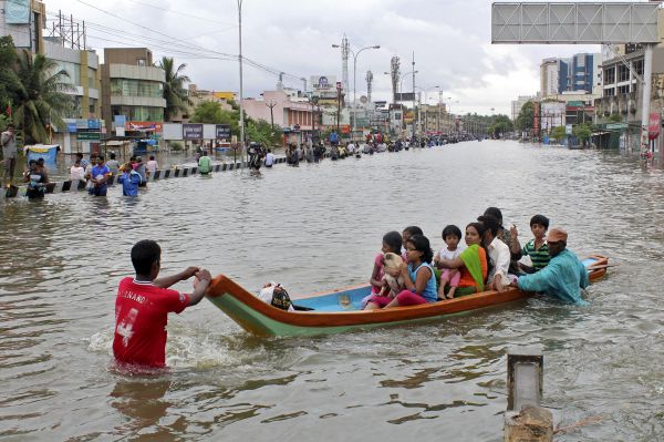People travel on a boat as they move to safer places through a flooded road in Chennai, December 2, 2015. REUTERS/Stringer